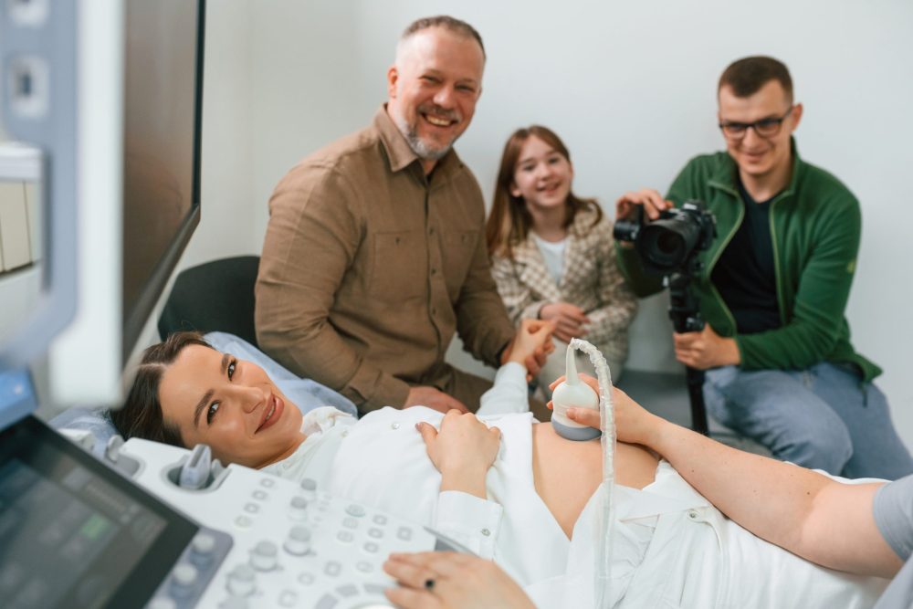 pregnant woman during ultrasound with her family